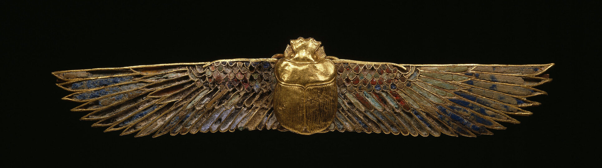 Golden figure of a scarab with bird’s wings